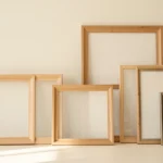 A set of empty picture frames in different rectangular shapes and orientations arranged on a wall