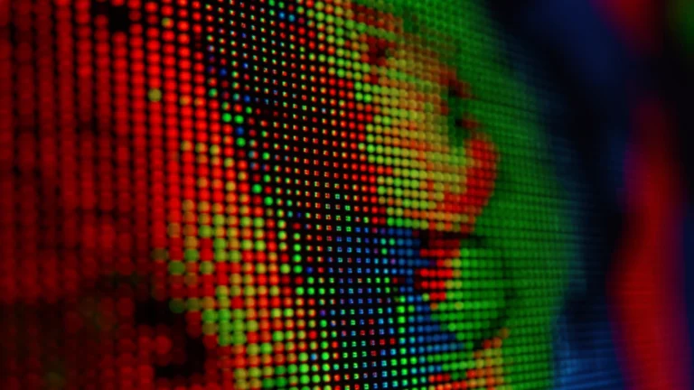 An extreme close-up of a screen showing individual red, green, and blue pixels forming part of an image