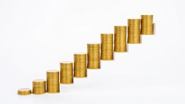 A rising staircase of coin stacks growing taller with each step, representing retirement savings targets that increase with age