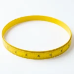 A soft measuring tape coiled into a circle on a plain background, a concept for waist-to-hip ratio, no text and no people