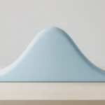 A smooth bell-shaped sculpture on a light desk with one thin tail edge colored differently, abstract statistics concept